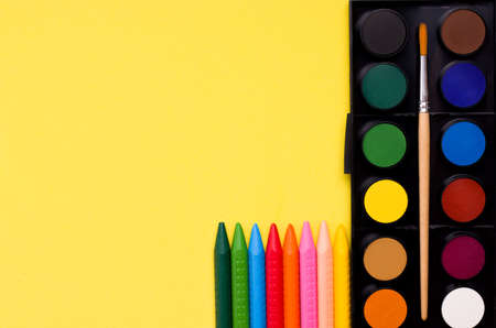 Creativity concept. Paints and crayons on a yellow background. Copy space. Bannerの写真素材