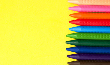 Crayons of different colors on a yellow background. Copy space. The concept of children's games and drawing.の写真素材