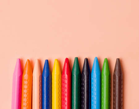 Crayons of different colors on a beige background. Copy spaceの写真素材