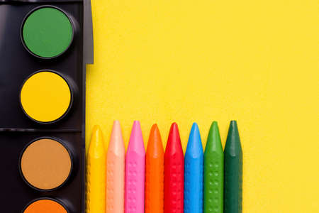 Paints and crayons pencils on a yellow background. Copy spaceの写真素材