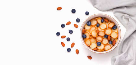 healthy tiny pancake cereal breakfast next to ingredients on a white plate. copy space. bannerの写真素材
