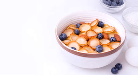 Cooking tiny pancake cereal. Flakes next to the ingredients on a white background. Copy space. Bannerの写真素材