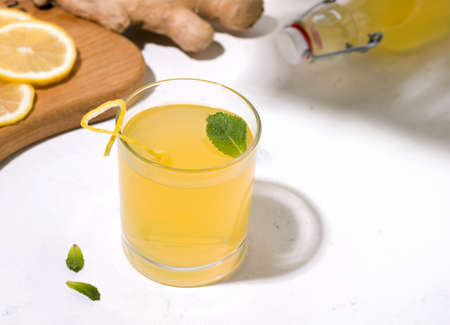 Kombucha fermented drink with ginger and lemon on a white backgroundの写真素材