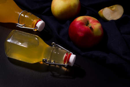 Fermented apple drink in bottles on a black backgroundの写真素材