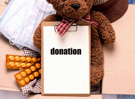 Donation concept. Toys, medicines, things and masks in a box.