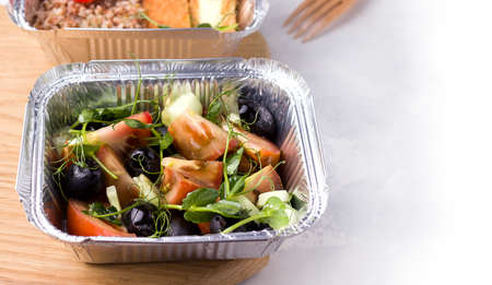 Wholesome and vegan food delivery. Fresh salad on a white background. Copy spaceの写真素材