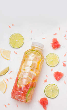 Sports drink in a bottle with lime, lemon and grapefruitの写真素材