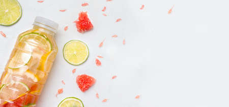 The concept of sports drinks. On a white background in a bottle is a drink with citrus. Copy space. Bannerの写真素材