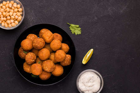 Vegan dish falafel. Fried ready-made balls in a bowl on a black background. View from above. Copy spaceの写真素材