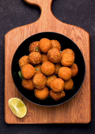 A Middle Eastern dish of falafel. Fried balls on a wooden board. vertical photoの写真素材