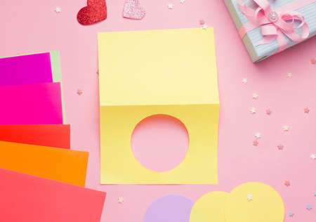 Happy Valentine's Day diy postcard step by step. Step one, fold a piece of colored paper in half and cut out a circle on one side.の写真素材