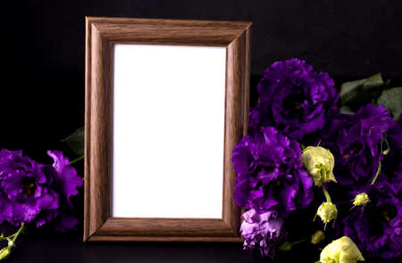 Empty mourning photo frame next to purple flowers. Sorrow conceptの写真素材