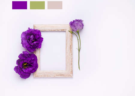 Wooden photo frame with purple flowers on a white background. Copy spaceの写真素材