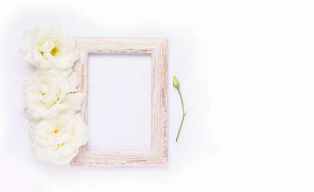 Mockup. Wooden photo frame next to white flowers. Copy spaceの写真素材