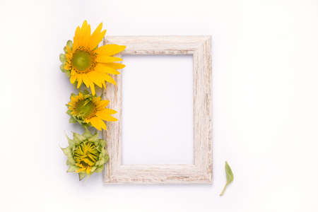 photo frame with sunflower flowers on a white wall.の写真素材