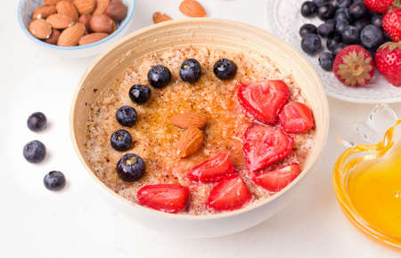 Healthy summer breakfast. Oatmeal porridge with fresh berries on a white plateの写真素材