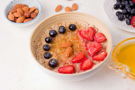 breakfast with porridge decorated with strawberries and blueberriesの写真素材