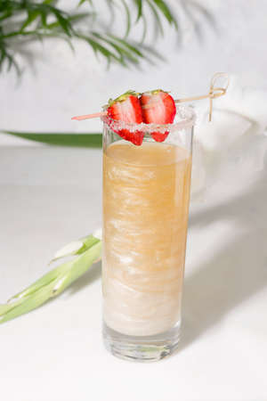 Drink with shimmer and strawberries in a glass on a white backgroundの写真素材