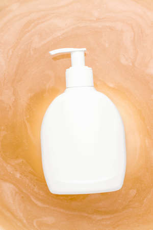 Mockup white dispenser bottle in orange waterの写真素材
