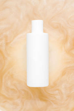 Mockup of cosmetic products. White bottle in water with a shimmer. vertical photoの写真素材
