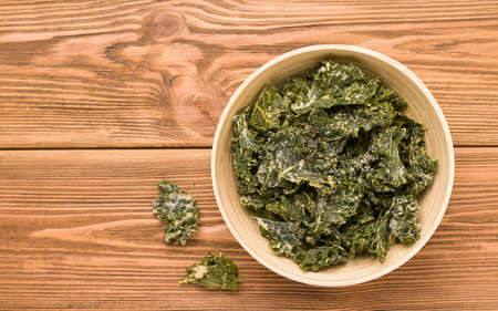 Kale chips on a wooden table. Copy spaceの写真素材