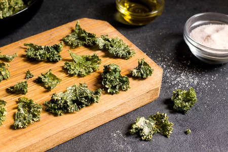 Kale chips on wood plankの写真素材
