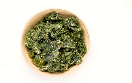 Kale chips in a bowl on a white background. View from aboveの写真素材