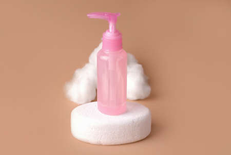 Mockup of cosmetics. Pink bottle with dispenser against beige backgroundの写真素材
