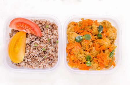 Vegetarian lunch in a container with buckwheat and soy meat with micro greens on a white plate. View from aboveの写真素材