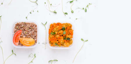 Vegetarian lunch in a container with porridge and soy meat on a white plate. copy space. bannerの写真素材