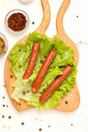 Vegetarian meat concept. Sausages from soybeans and spices on a wooden board. Vertical photo, top viewの写真素材