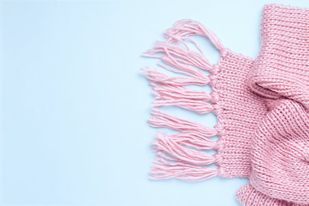 Pink warm knitted scarf on a blue background. Copy space. View from above. Bannerの写真素材
