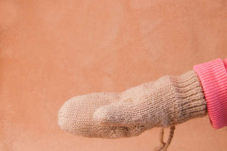 Hand in warm glove on brown background .mock upの写真素材