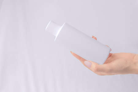 Mock up cosmetics. White bottle of shampoo, gel in a woman's hand.の写真素材