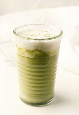 Matcha latte on a white plate close-up.の写真素材