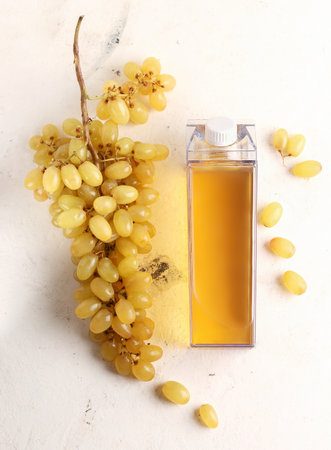Grape juice mock up. A bottle with juice on a white background next to the grapes ingredients. view from aboveの写真素材