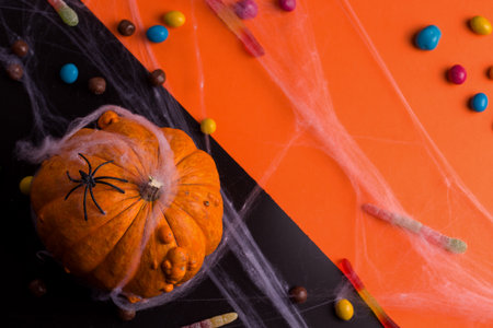 Halloween holiday. Against a background of black and orange pumpkin and sweets. Copy spaceの写真素材