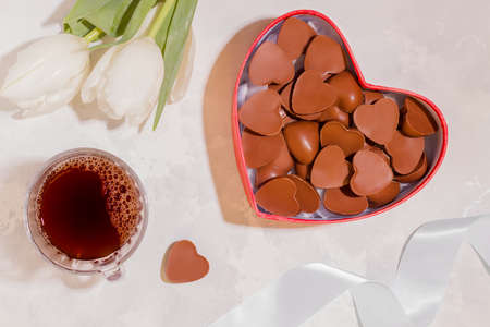 Celebratory breakfast concept. Sweets, coffee and flowers on a white background