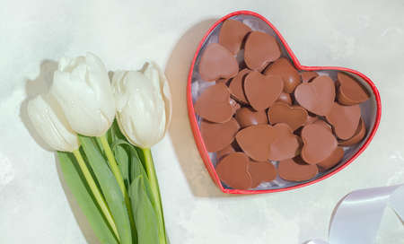 woman gift concept. On a white background tulips and chocolate candies.
