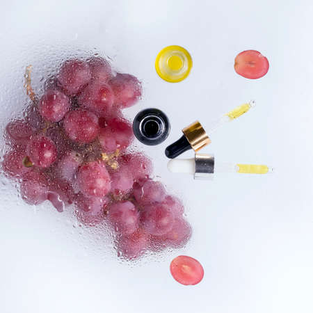 Grape-based cosmetic oil. Copy space. Light backgroundの写真素材