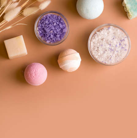 Bath cosmetics. Salt, bath bombs and soap on a brown background. Copy space. View from aboveの写真素材