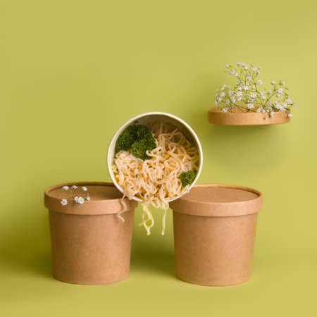 Food delivery concept. Noodles in a glass on a green backgroundの写真素材