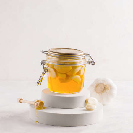 Fermented honey with garlic on a gray pedestal. Copy spaceの写真素材