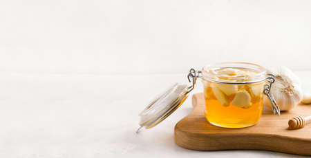 Fermented honey with garlic on a wooden board. Copy space. Bannerの写真素材