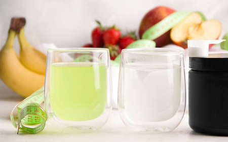 White and green drinks for athletes in glasses. White backgroundの写真素材
