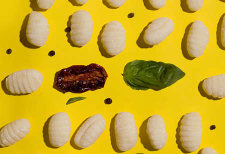 Gnocchi is a traditional vegetarian italian dish on a yellow background. view from aboveの写真素材
