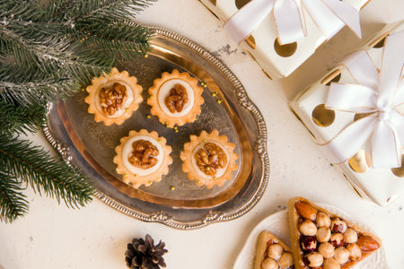 The concept of New Year's sweets. Cookies with nuts and cream on a tray. View from aboveの写真素材
