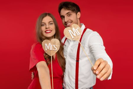 Selective focus of smiling beautiful young couple have fun together in elegant outfitの写真素材