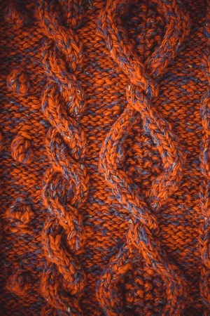 background knitted braids with red thread closeupの写真素材