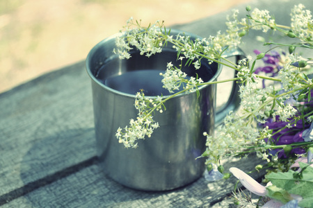 cup of tea standing on a table with blooming flowers, filterの写真素材